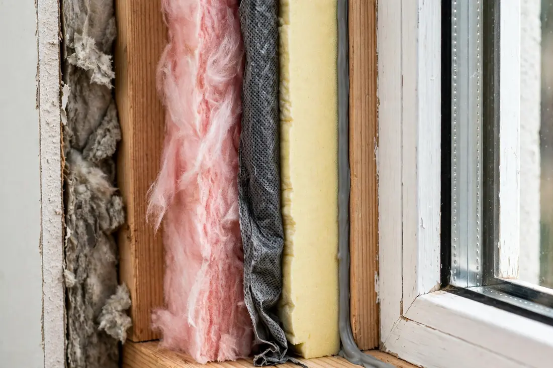 craftsman installing a white vinyl replacement window in bright daylight