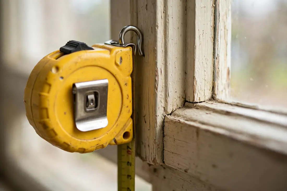 tape measure held against a window frame during measurement